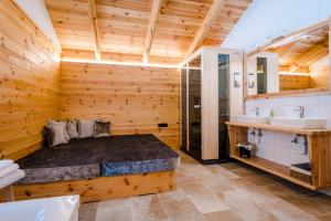 una camera da letto in stile baita di tronchi con letto e lavandino di Hochleben-Chalets am Erlebnisbauernhof Steinerhof a Liebenfels Altre 37 foto