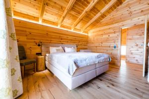 una camera da letto con un letto in una stanza di legno di Hochleben-Chalets am Erlebnisbauernhof Steinerhof a Liebenfels