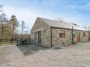 a stone house with a picnic table in front of it at Bear Lake Lodge in Alderwasley