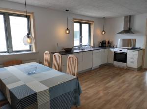 una cucina e una sala da pranzo con tavolo e sedie di Hjortdal B&B a Fjerritslev