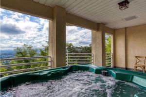 a jacuzzi tub on a balcony with a view at The Great Escape chalet in Sevierville