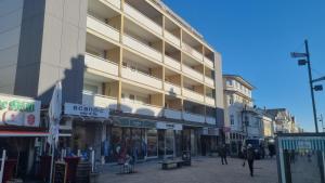 a building on a street with people walking in front of it at Ferienhaus Christianenhöhe App 34 in Westerland (Sylt)