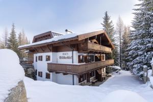 a building in the snow with snow covered trees at Haus Wildkarblick in Krimml