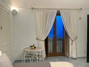 a room with a table and a window with a view at Villa Hermosa Costiera Amalfitana in Amalfi