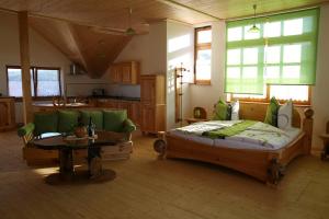 ein Schlafzimmer mit einem Bett, einem Sofa und einem Tisch in der Unterkunft Ferienwohnung Gmeinwieser in Mitterfecking