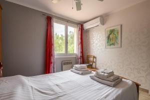 sypialnia z łóżkiem i ręcznikami w obiekcie Villa Cosy w mieście Moussan