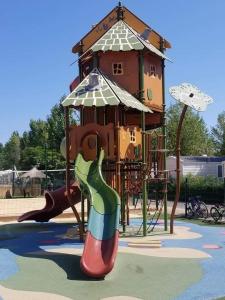 维亚斯Mobilhome Vias plage dans Camping的一个带滑梯和塔的游乐场