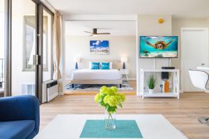 a living room with a bed and a vase of flowers at Fabulous Ocean & Diamond Head View with Free Parking! in Honolulu
