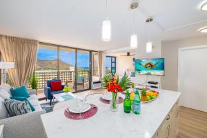 a kitchen and living room with a couch and a table at Fabulous Ocean & Diamond Head View with Free Parking! in Honolulu