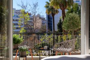 a balcony with two chairs and a view of a city at Acropolis Deluxe 2BR Apartment in Athens