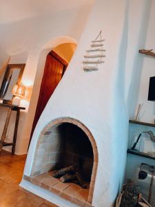 een woonkamer met een stenen open haard en een houten deur bij Sa caseta de Fornells in Es Mercadal