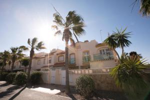 una casa grande con palmeras delante en Chalet asosado, en Almerimar