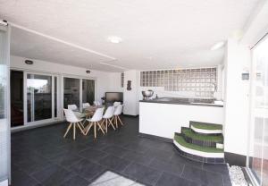 a kitchen and living room with a counter and chairs at Chalet asosado in Almerimar