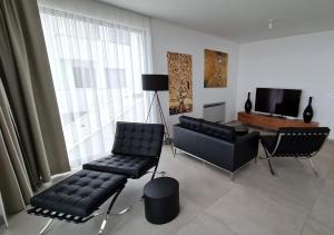uma sala de estar com um sofá, uma cadeira e uma mesa em Kvarner Luxus Suite am Meer em Lovran