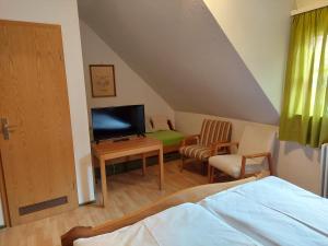 a bedroom with a bed and a tv and a chair at Gasthaus zur Krone in Weisenbach