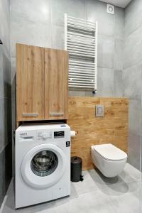 a washing machine in a bathroom with a toilet at SKi&bike apartments Laguna Zarzecze in Zarzecze