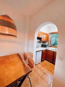 een keuken met een houten tafel in een kamer bij Sa caseta de Fornells in Es Mercadal