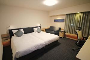 Habitación de hotel con cama y silla en Richmond Hotel Premier Musashikosugi, en Kawasaki