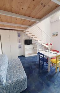 uma sala de estar com uma mesa e cadeiras e uma escadaria em sea home em Bacoli