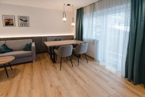 a living room with a table and chairs and a couch at Winkler Appartements in Saalbach Hinterglemm