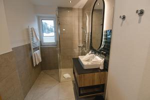 a bathroom with a sink and a mirror at Winkler Appartements in Saalbach Hinterglemm