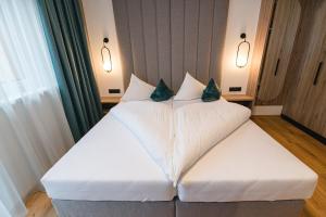 a hotel room with a bed with two pillows at Winkler Appartements in Saalbach Hinterglemm