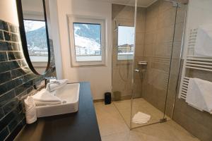 a bathroom with a glass shower and a sink at Winkler Appartements in Saalbach Hinterglemm