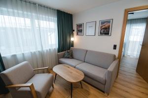 a living room with a couch and a table at Winkler Appartements in Saalbach Hinterglemm