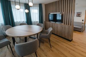a conference room with a table and chairs and a tv at Winkler Appartements in Saalbach Hinterglemm