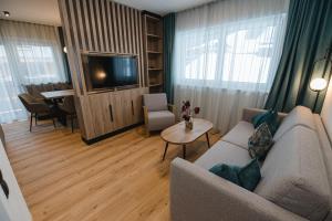 a living room with a couch and a tv and a table at Winkler Appartements in Saalbach Hinterglemm