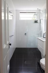 a bathroom with a shower and a toilet and a sink at Woodland Bay Retreat-Luxury Hamptons Retreat in Lymington