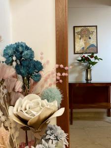 La Dogaressa Guest House في البندقية: غرفة فيها صورة لامرأة وزهور