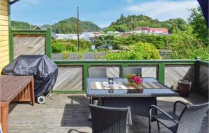a patio with a table and chairs on a deck at Gorgeous Home In Farsund With Kitchen in Farsund