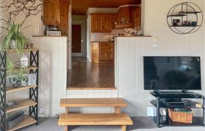 sala de estar con TV y banco de madera en Gorgeous Home In Farsund With Kitchen, en Farsund