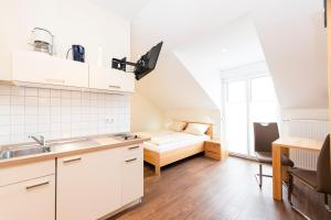uma cozinha com um lavatório e uma cama num quarto em Weingut und Gastehof Borst em Nordheim