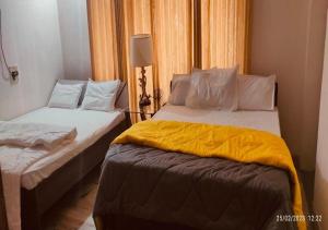 ハイデラバードにあるBest Individual Home stay Near Apollo Jubilee Hillsのベッドルーム1室(黄色いシーツを使用したベッド2台付)