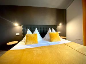 a bedroom with a large bed with yellow pillows at Apartements and rooms next to the Sea - Belveder Rab in Rab