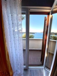 a room with a window with a view of the ocean at Apartements and rooms next to the Sea - Belveder Rab in Rab