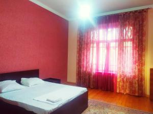 una camera da letto con un letto e una parete rossa di KOSHGARI APARTMENT a Samarkand