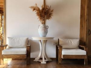 a table with a vase on it next to two chairs at Costa Bodrum City in Bodrum City