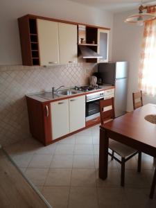 a kitchen with a sink and a stove top oven at Apartman Branka in Rab