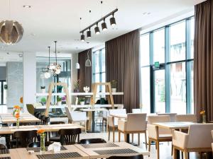 - un restaurant avec des tables, des chaises et de grandes fenêtres dans l'établissement ibis Styles Siedlce, à Siedlce