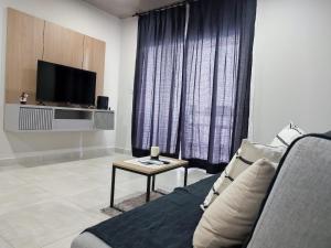 uma sala de estar com um sofá, uma televisão e uma mesa em Impecable y nuevo, zona aeropuerto! em Assunção