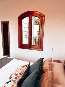 een slaapkamer met een raam en een bed met kussens bij Sa caseta de Fornells in Es Mercadal