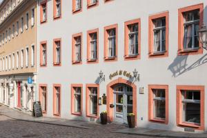 a white building with red windows and a door at Hotel GARNI Residenz Am Markt Meißen in Meißen