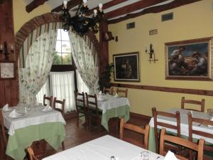 a dining room with two tables and a chandelier at Hotel Las Ruedas in Laredo