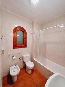 een badkamer met een toilet, een wastafel en een bad bij Sa caseta de Fornells in Es Mercadal