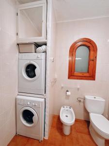 a bathroom with a washing machine and a toilet at Sa caseta de Fornells in Es Mercadal