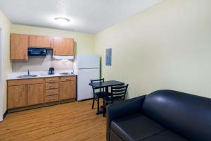 a kitchen with a couch and a table in a room at Suburban Studios Lewisville in Lewisville