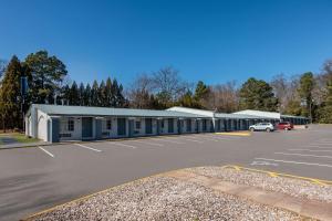 a parking lot with a building with a car parked in it at Rodeway Inn Charlotte Airport Area in Charlotte